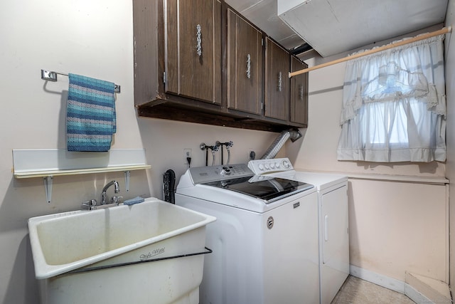 clothes washing area featuring cabinet space, separate washer and dryer, and a sink