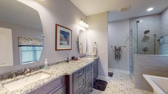 bathroom with double vanity, a stall shower, baseboards, and a sink