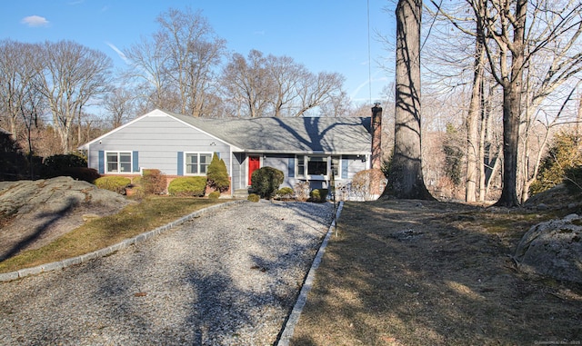 view of front of property featuring gravel driveway and a chimney