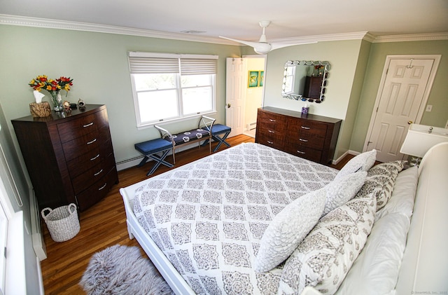 bedroom featuring dark wood-type flooring, baseboard heating, and crown molding