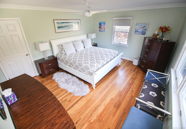 bedroom featuring ornamental molding, light wood-style flooring, and baseboards