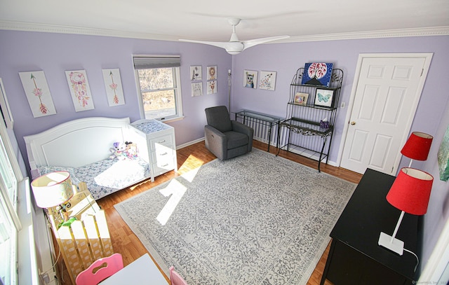 bedroom with crown molding, baseboards, and wood finished floors