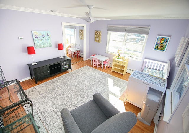 rec room featuring baseboards, ceiling fan, ornamental molding, wood finished floors, and a baseboard heating unit