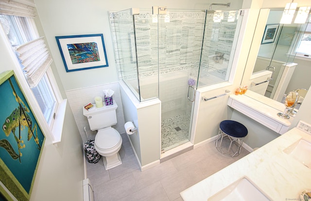 bathroom with tile patterned flooring, toilet, vanity, tile walls, and a stall shower