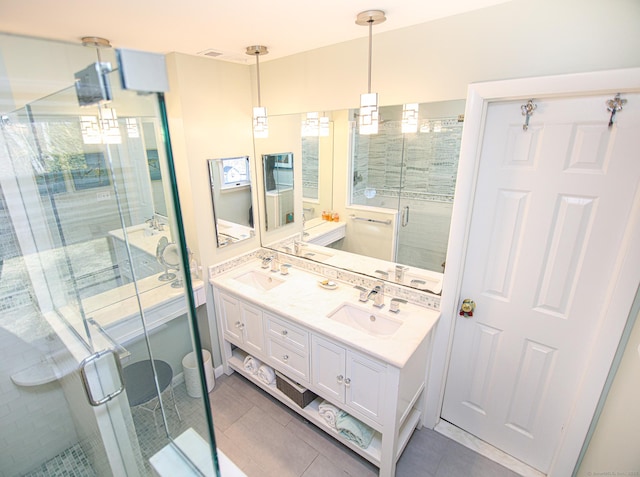 bathroom featuring tile patterned flooring, a sink, a shower stall, and double vanity