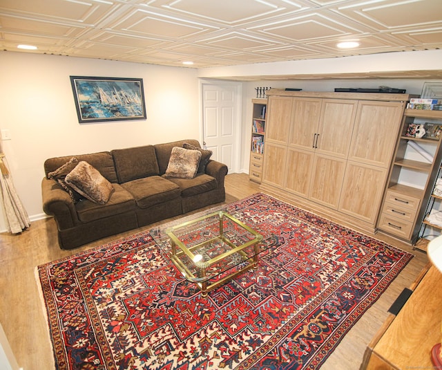 living area with an ornate ceiling, light wood-style flooring, and baseboards