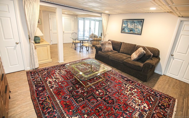 living area featuring an ornate ceiling, baseboards, and wood finished floors