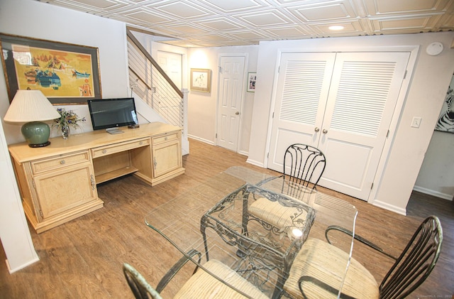 office area featuring light wood finished floors, an ornate ceiling, baseboards, and french doors