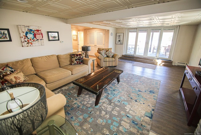 living area with an ornate ceiling, baseboard heating, and wood finished floors