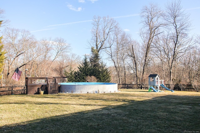 view of yard featuring a playground and a covered pool