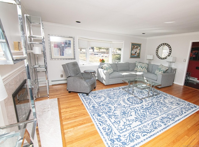 living area with a baseboard heating unit, ornamental molding, a premium fireplace, and wood finished floors