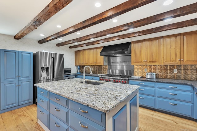 kitchen featuring extractor fan, blue cabinetry, stainless steel refrigerator with ice dispenser, and a sink