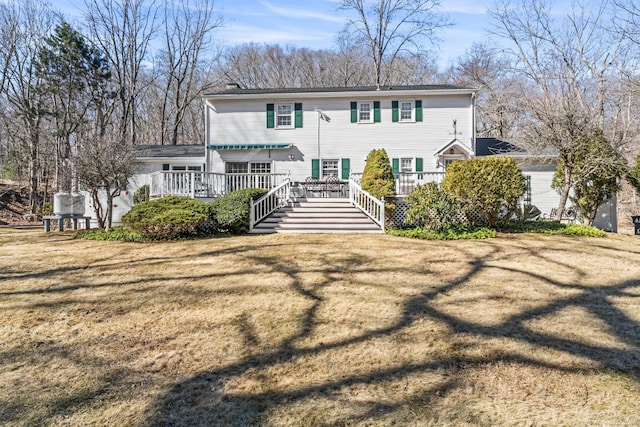 rear view of house featuring a deck and a yard