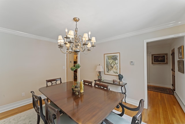 dining room featuring light wood finished floors, a baseboard heating unit, and ornamental molding