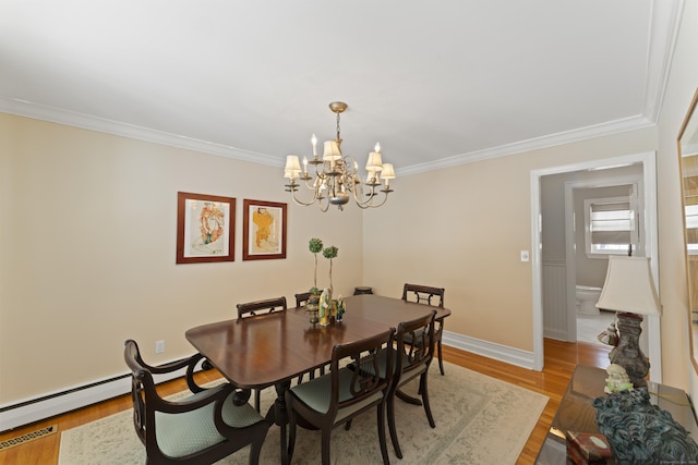 dining space featuring light wood-style floors, baseboards, a chandelier, and crown molding