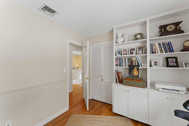 interior space with light wood-style flooring, visible vents, and baseboards