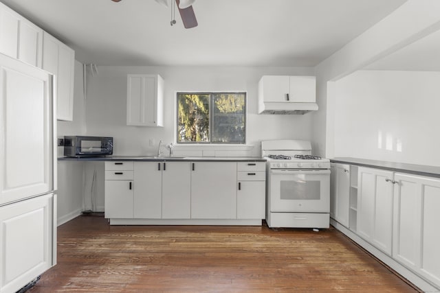 kitchen featuring dark wood finished floors, white cabinetry, black microwave, a sink, and white range with gas stovetop