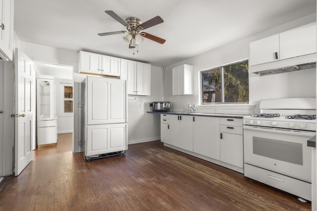 kitchen featuring under cabinet range hood, white range with gas stovetop, a sink, white cabinetry, and dark wood-style floors