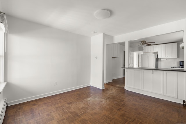 unfurnished living room featuring ceiling fan, baseboards, and baseboard heating