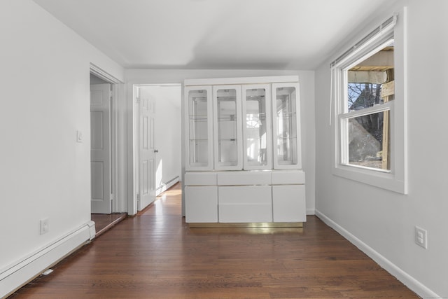 interior space featuring dark wood-style floors, a baseboard radiator, baseboards, and baseboard heating