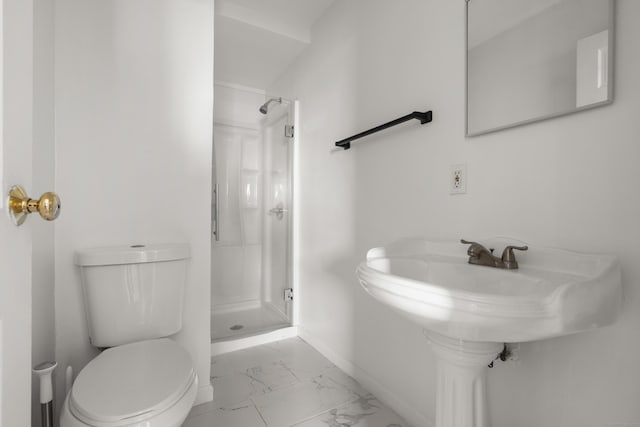 bathroom with baseboards, toilet, marble finish floor, a shower stall, and a sink