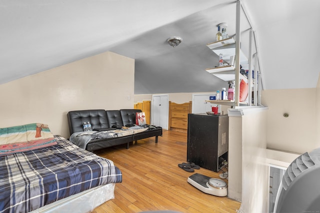 bedroom with lofted ceiling and wood-type flooring