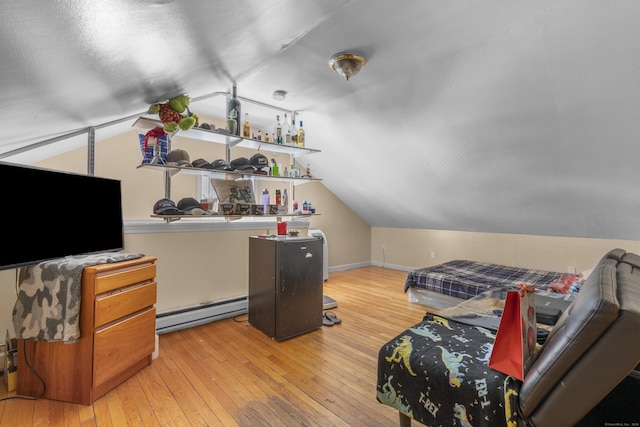 bedroom featuring lofted ceiling, a baseboard radiator, baseboards, and hardwood / wood-style floors