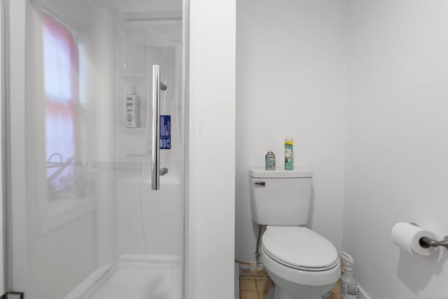 bathroom featuring a wealth of natural light, a stall shower, and toilet