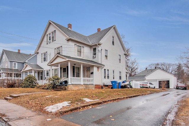 view of front of house with a detached garage, a chimney, roof with shingles, covered porch, and an outdoor structure