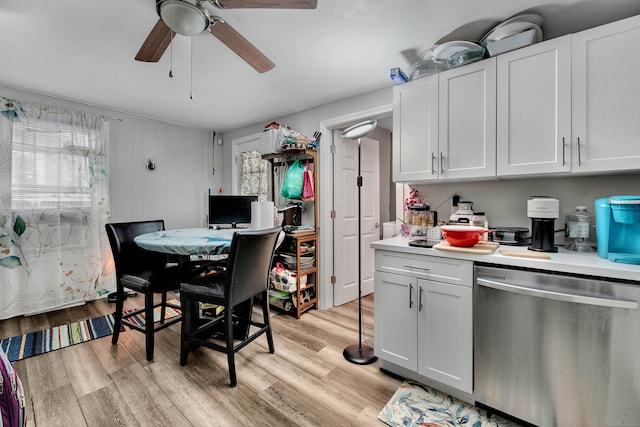 kitchen with light wood-type flooring, light countertops, stainless steel dishwasher, and white cabinetry