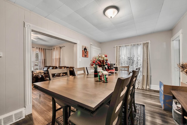 dining area featuring dark wood-style flooring, visible vents, and a healthy amount of sunlight