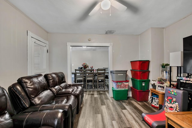 living area featuring wood finished floors, visible vents, and a ceiling fan