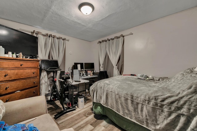 bedroom featuring light wood finished floors and a textured ceiling