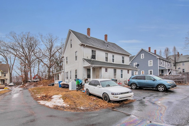 view of front of property with a shingled roof and a chimney