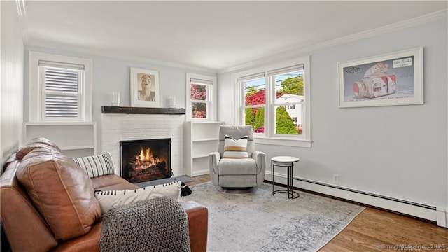 sitting room with a baseboard radiator, a fireplace, ornamental molding, and wood finished floors