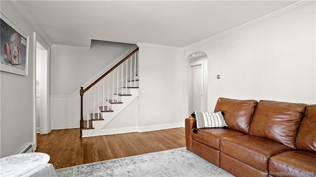 living area with arched walkways, stairway, ornamental molding, wood finished floors, and baseboards