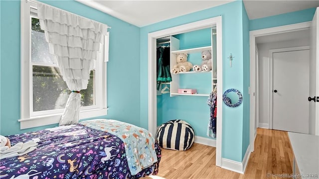 bedroom with baseboards and wood finished floors