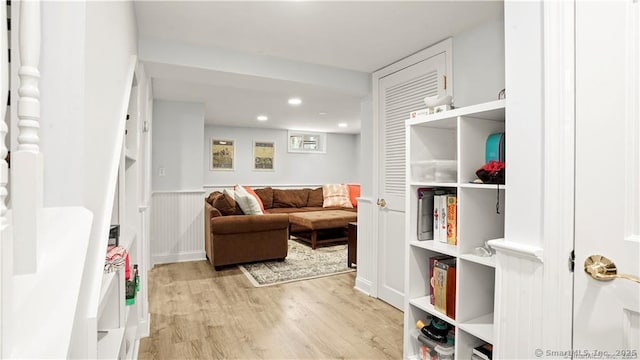 living area featuring light wood-type flooring, a wainscoted wall, and recessed lighting