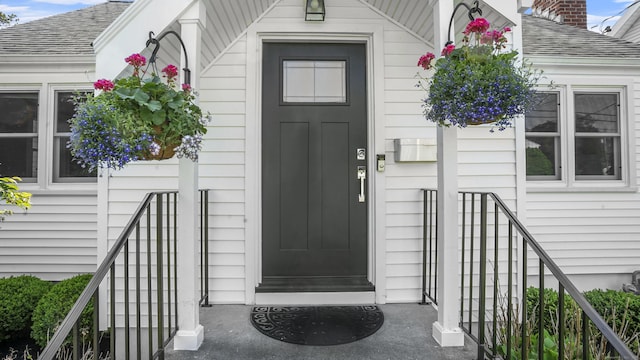 property entrance featuring roof with shingles