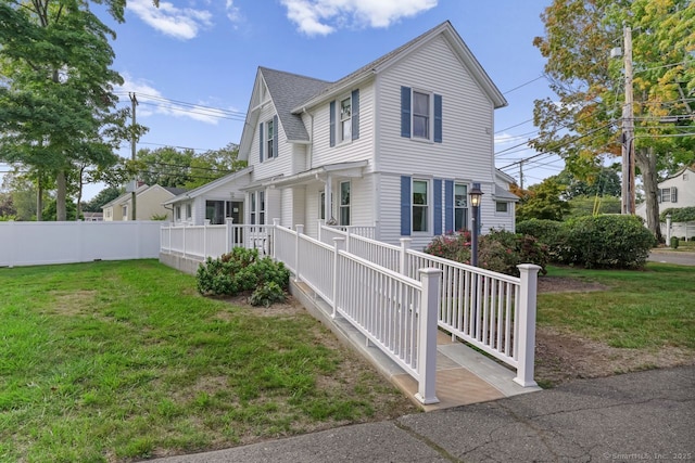 view of side of home featuring a shingled roof, fence, and a lawn