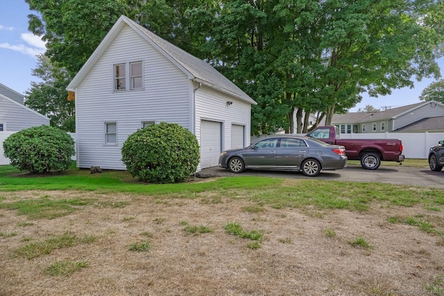 exterior space with aphalt driveway and a yard