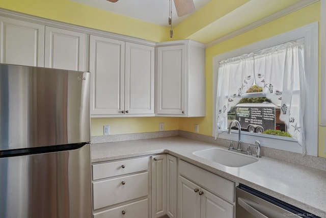 kitchen with appliances with stainless steel finishes, white cabinets, and a sink