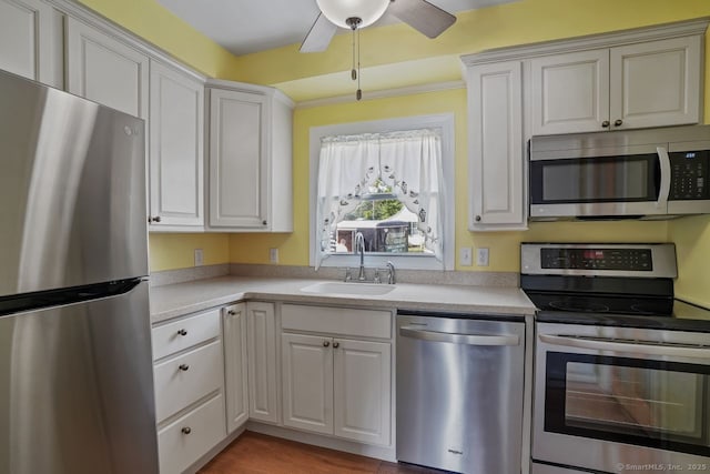 kitchen with ceiling fan, a sink, white cabinets, light countertops, and appliances with stainless steel finishes