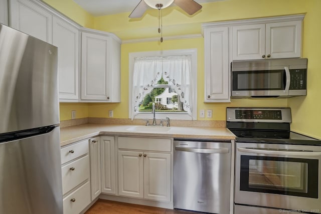 kitchen with a ceiling fan, stainless steel appliances, a sink, and light countertops