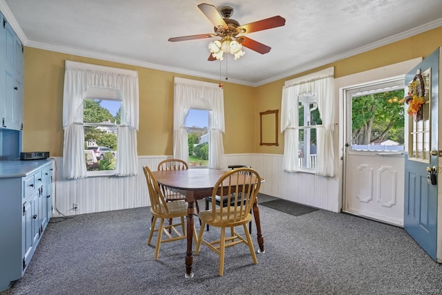 dining area with carpet floors, a wainscoted wall, and ornamental molding