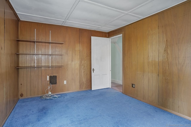 carpeted empty room with wooden walls