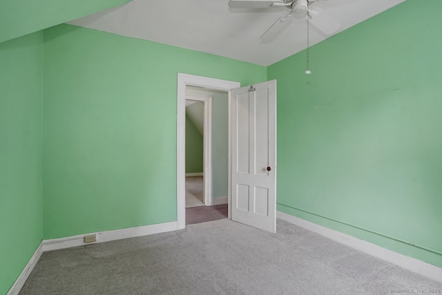 carpeted empty room with ceiling fan and baseboards