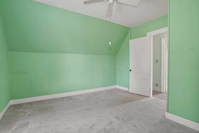 additional living space with vaulted ceiling, carpet floors, a ceiling fan, and baseboards