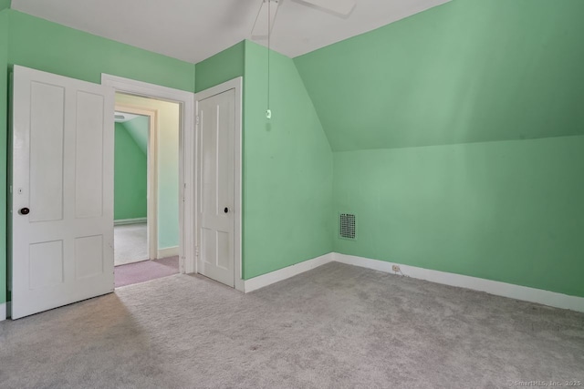 additional living space featuring carpet, visible vents, baseboards, and vaulted ceiling