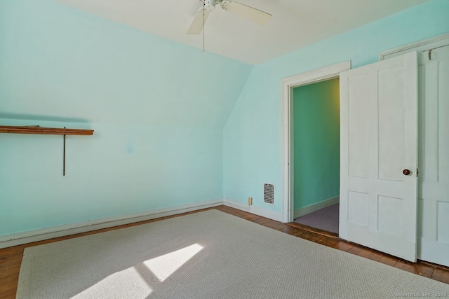 additional living space featuring a ceiling fan, vaulted ceiling, baseboards, and wood finished floors